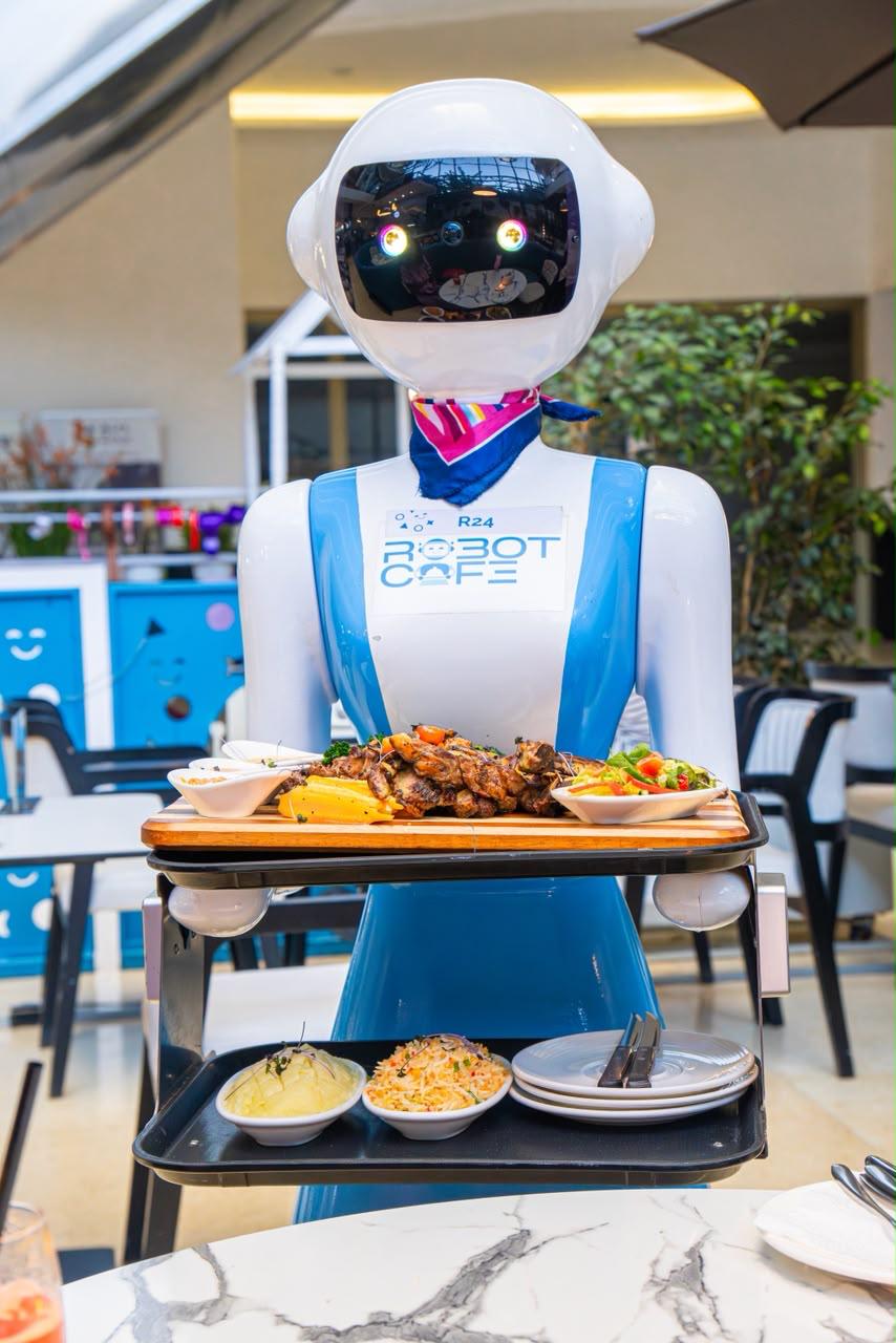 A Robot Cafe robot waiter carrying loaded trays of grilled food and sides